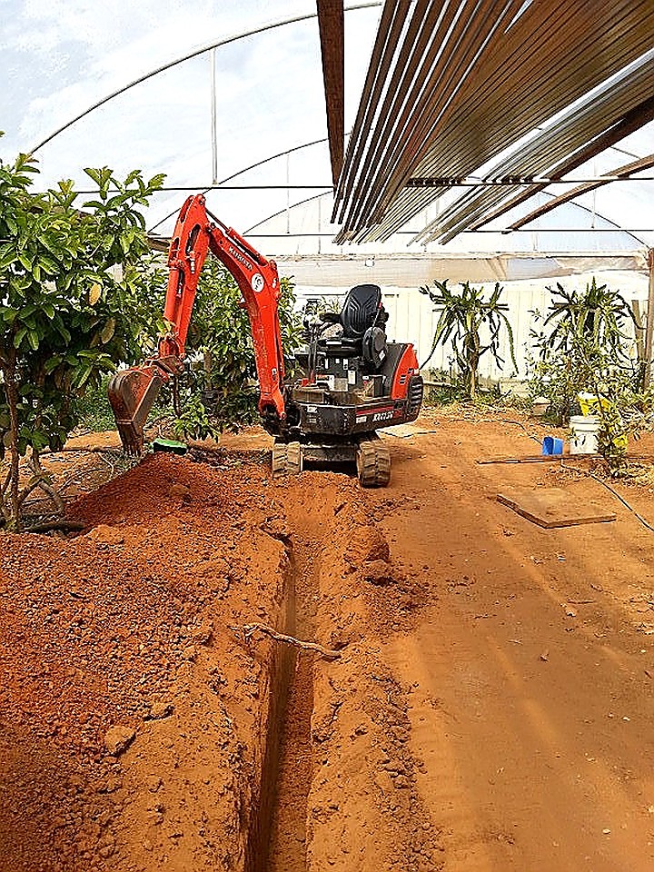 Trenching through a garden bed under cover